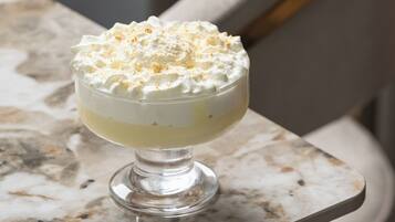 A dessert in a glass bowl on a marble table.