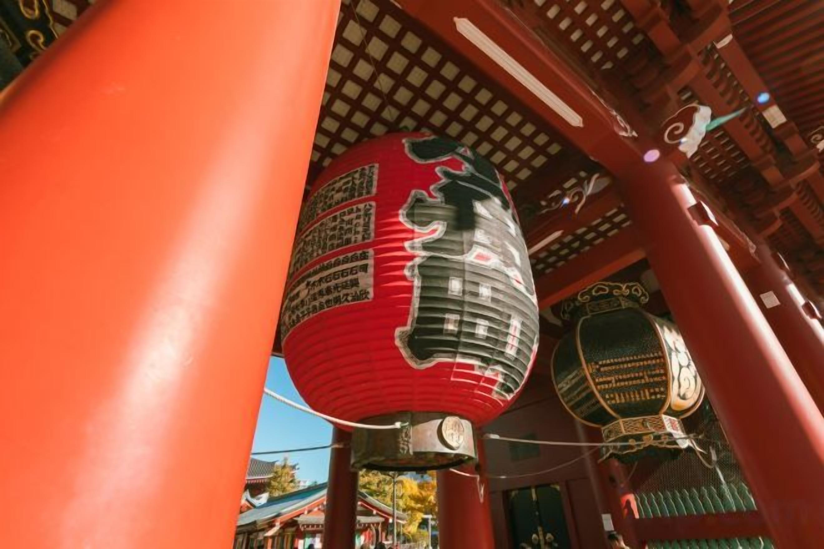 A traditional Japanese building with a red torii gate and a hanging lantern.