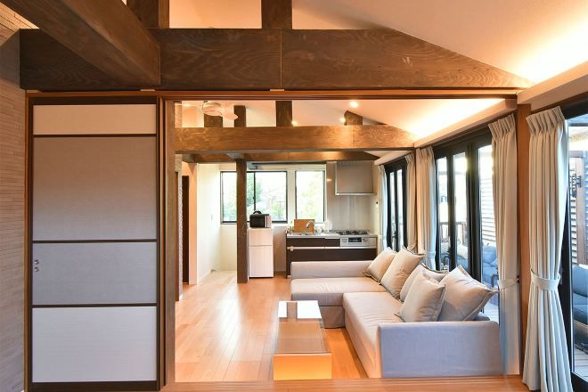 A modern living room with a sofa, a coffee table, and a kitchen area in the background.