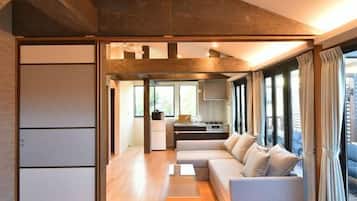 A modern living room with a sofa, a coffee table, and a kitchen area in the background.