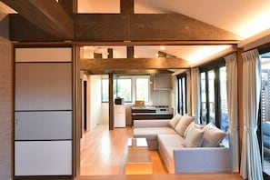 A modern living room with a sofa, a coffee table, and a kitchen area in the background. - KandoStay Asakusa East Terrace (Tokyo)