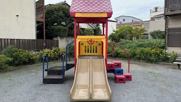A playground with a slide and climbing structures.