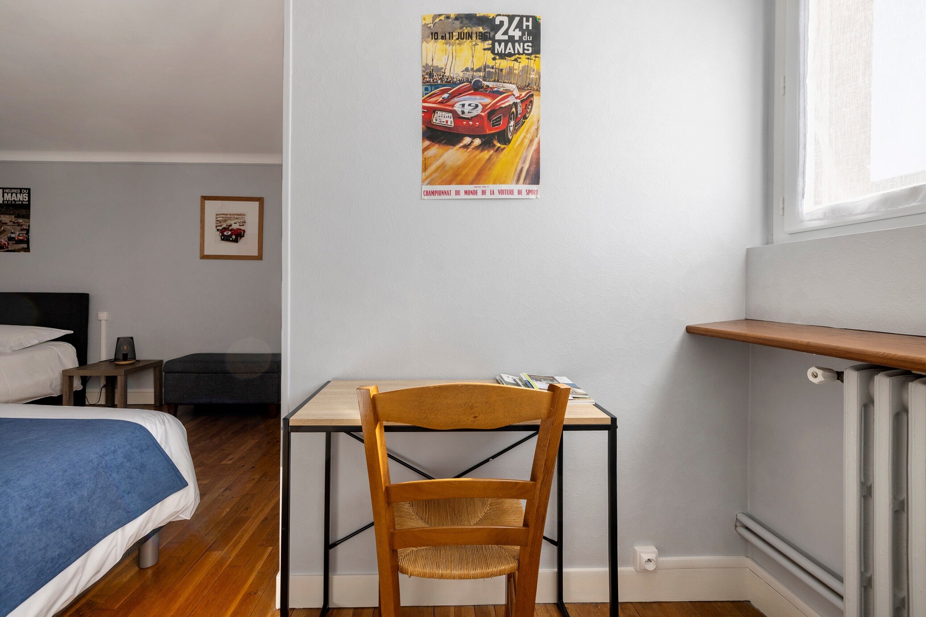 Une chambre à coucher avec un lit, un bureau, une chaise et une affiche accrochée au mur.