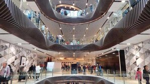 A multi-level atrium with a modern design, featuring a central open space surrounded by curved balconies. - A Chic 2BR Apt Near Melbourne Uni, FREE Parking (Carlton)