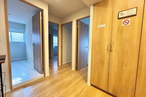 A hallway with wooden doors, a sign indicating 'No Smoking,' and a view into a room with a window. - Luxurious stay with a rooftop balcony of over 100 square meters! (Tokyo)