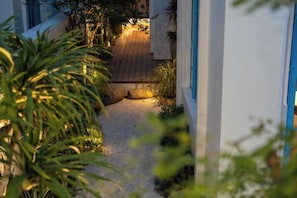 A pathway leading to a wooden deck area surrounded by greenery. - domdomHOUSE Villa - 1min to beach (Ha Long)