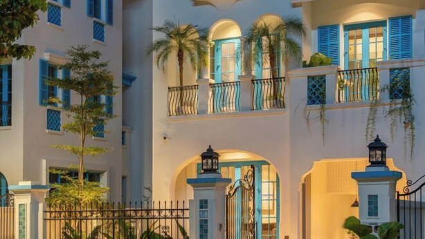A multi-story building with balconies, arched doorways, and a gated entrance. - domdomHOUSE Villa - 1min to beach (Ha Long)