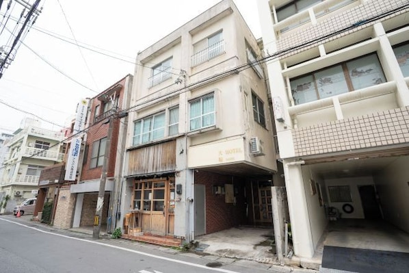 A multi-story building with a ground-level commercial space and upper residential units. - DAIJUN HOTEL (Naha)