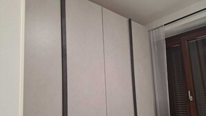 A room with a wardrobe, a window with blinds, and a door. - Starlight Apartment (Garbagnate Milanese)