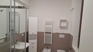 A bathroom with a glass shower enclosure, a sink, a bidet, and a toilet. - Starlight Apartment (Garbagnate Milanese)