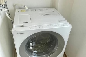 A white Panasonic washing machine in a corner of a room. - YMK Oshiage 7B (Tokyo)