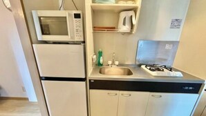 A compact kitchen with a microwave, refrigerator, sink, and dishwasher. - YMK Oshiage 7B (Tokyo)