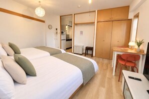 A hotel room with two beds, a desk, and a chair. - YMK Oshiage 7B (Tokyo)