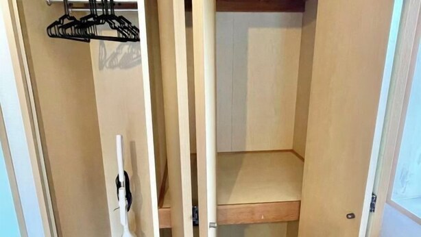 A closet with wooden doors, a hanging rack, and a vacuum cleaner. - YMK Oshiage 7B (Tokyo)