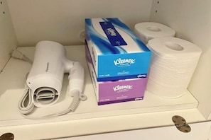 A shelf with a hair dryer, Kleenex boxes, and toilet paper. - YMK Oshiage 7B (Tokyo)