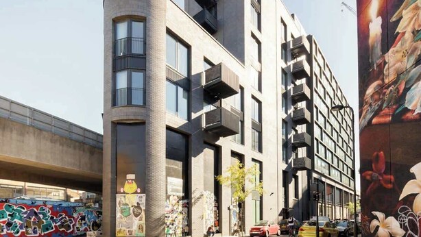 A modern building with a curved facade, large windows, and balconies. - Urban Minimalist Apartment with Private Balcony (Greater London)