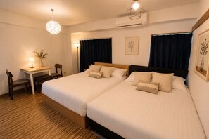 A double bed with white linens, a desk with a chair, and a small table with a lamp. - YMK Oshiage 6B (Tokyo)