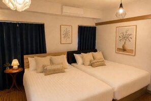 A hotel room with two beds, a small table with a lamp, and artwork on the walls. - YMK Oshiage 6B (Tokyo)
