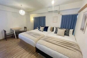 A hotel room with two beds, a desk, and a chair. - YMK Oshiage 6B (Tokyo)