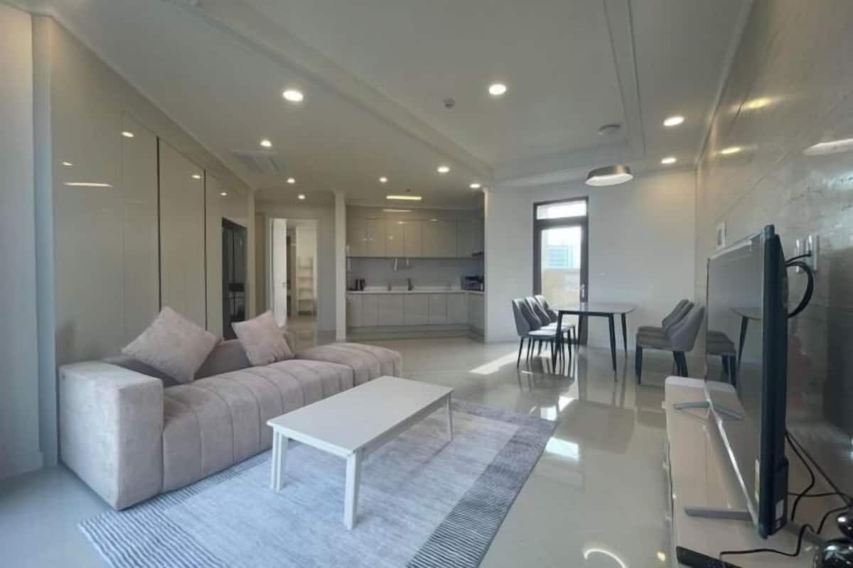 A modern living room with a sofa, a coffee table, and a TV.