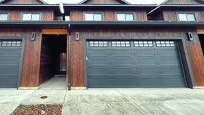 A two-story building with a garage entrance and a driveway.