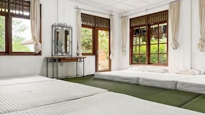 A room with two beds, a desk, a mirror, and large windows with curtains. - Large Bogor Villa w/ Pool, BBQ Grill& Fishing Spot (Cigombong)