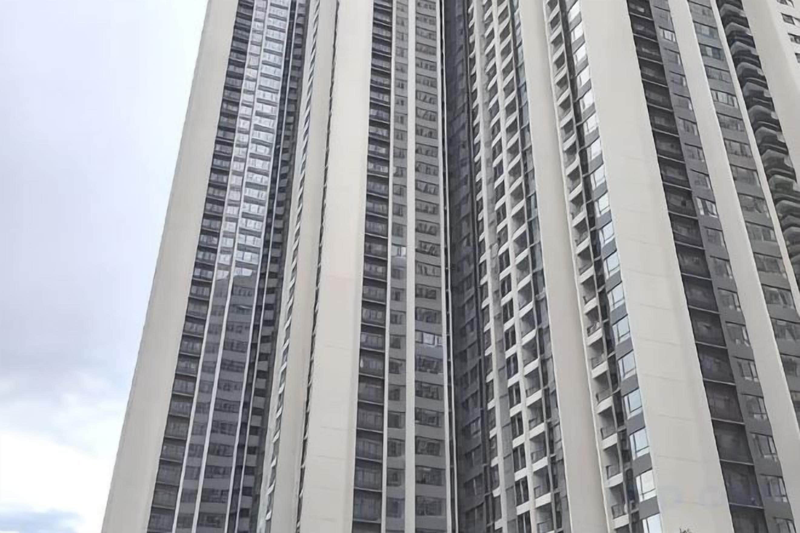 Un edificio alto de varios pisos, con numerosas ventanas y balcones.