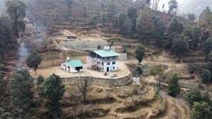 A two-story building with a green roof, surrounded by terraced fields and sparse vegetation. - Beyond Wifi Burans Kot Heritage (Nainital)