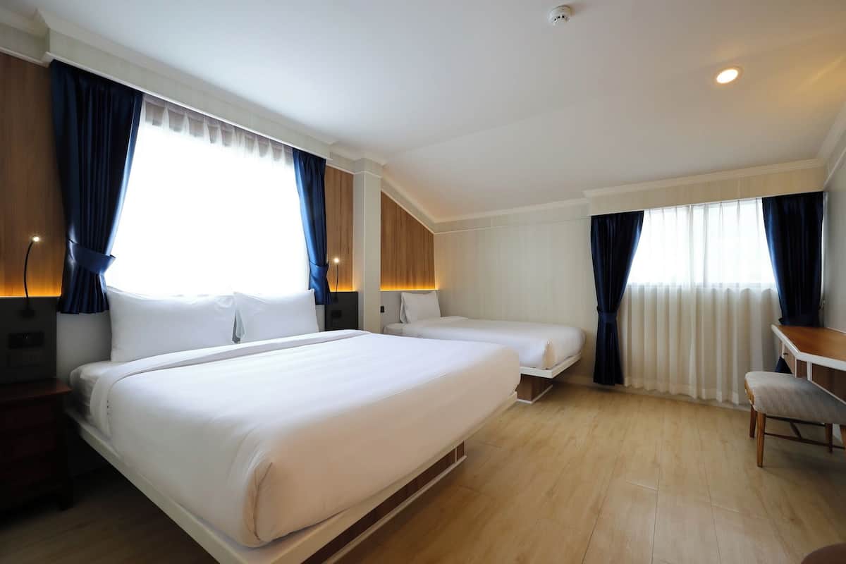Een hotelkamer met twee bedden, een bureau en een stoel.