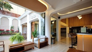 Eine moderne Hotelhalle mit einer Holzbank, einer Sitzgelegenheit und einem Empfangstisch.