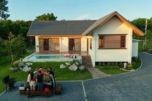 A modern house with a swimming pool, a covered patio, and a well-maintained garden. - Harper Pool Villa Khaoyai 3 Bedroom, 3 Bathroom (Pak Chong)
