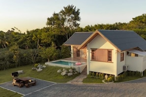 A modern house with a swimming pool, surrounded by a garden and trees. - Harper Pool Villa Khaoyai 3 Bedroom, 3 Bathroom (Pak Chong)