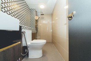 A modern bathroom with a toilet, shower, and patterned wall. - Sunway GRID Residence Legoland (Iskandar Puteri)