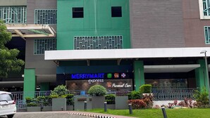A modern building with a green facade, a MerryMart Express store, and a Personal Care section.