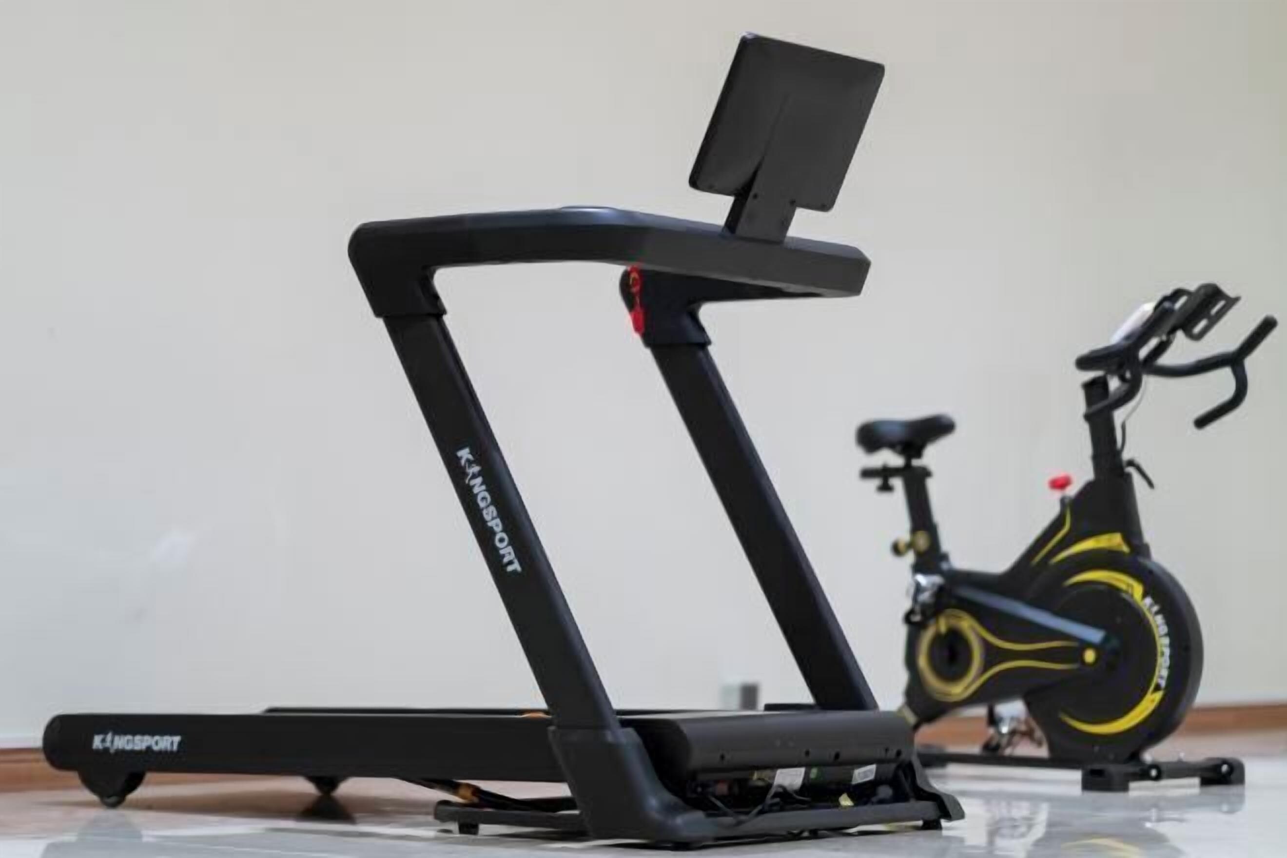 A treadmill and a stationary bike in a room.