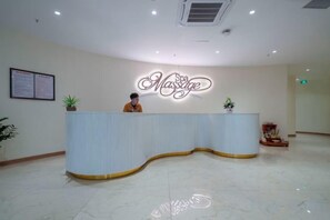 A reception desk with a neon sign, a potted plant, and a framed menu on the wall. - Hung Vuong Hotel (Mong Cai)