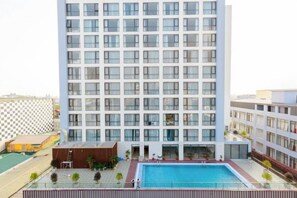 A multi-story hotel with a swimming pool and a tennis court. - Hung Vuong Hotel (Mong Cai)