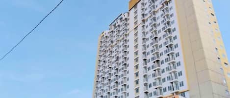 A high-rise building with multiple balconies and a sign reading "METROPOLITAN PARK".