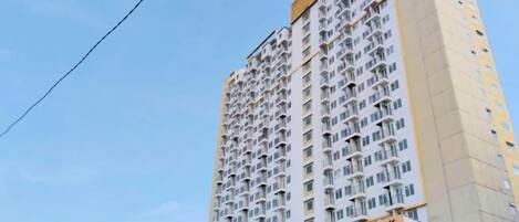 A high-rise building with multiple balconies and a sign indicating 'METROPOLITAN PARK'.
