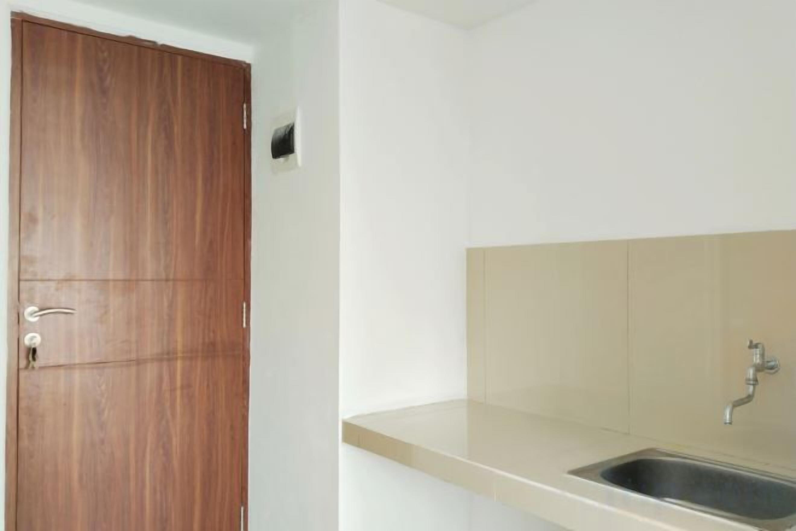A kitchenette with a wooden door, a sink, and a countertop.