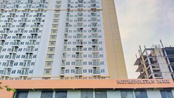 Un edificio de gran altura con varios balcones y un cartel que dice 'METROPOLITAN PARK'.