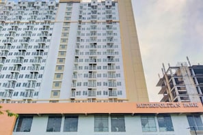 Un edificio de gran altura con varios balcones y un cartel que dice 'METROPOLITAN PARK'.