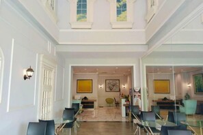 A spacious lobby with a high ceiling, a central seating area, and a view into another room. - Nusantara Metropolitan Park By Reccoma (North Bekasi)