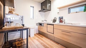 A modern kitchen with a built-in oven, a coffee machine, and a window. - Ikebukuro Japandi Villa (Tokyo)