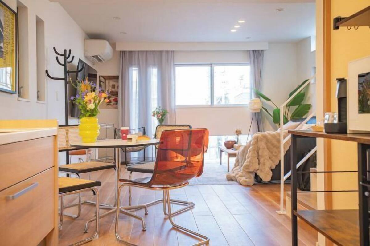 Una cocina moderna con comedor, sofá y escalera.