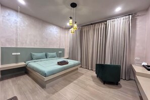 A modern bedroom with a bed, bedside tables, a bench, and a green chair. - Baanjeab in khaoyai (Pak Chong)