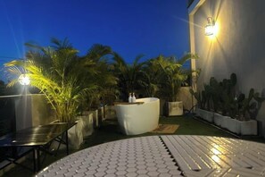 A rooftop terrace with a round table, a white cushioned seating area, and potted plants. - Baanjeab in khaoyai (Pak Chong)