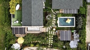 An aerial view of a residential property with a swimming pool, green lawn, and a garage. - Baanjeab in khaoyai (Pak Chong)