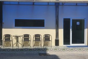 A building with a flat facade, a large window, and a door with glass panels. - Rustic Comfort Zone (Pattaya)