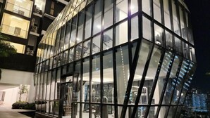 A modern building with a glass facade and multiple balconies. - Urban Muji Retreat Suites (George Town)